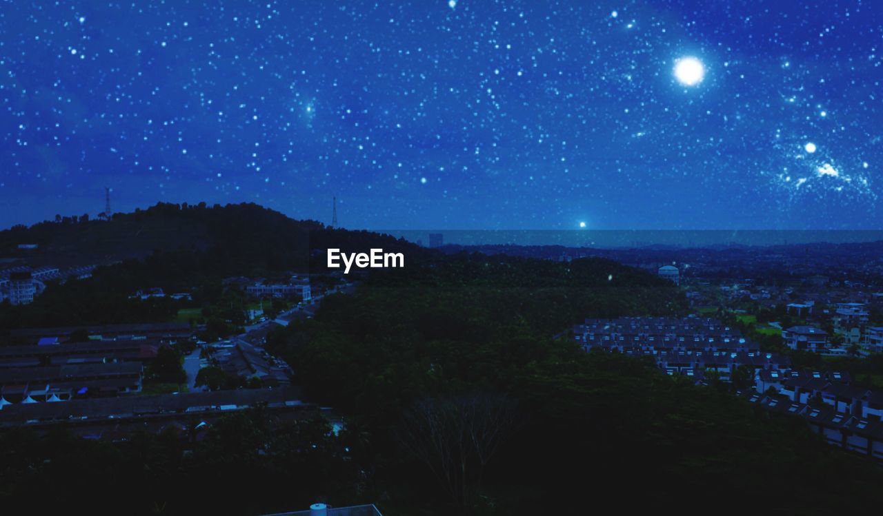 SCENIC VIEW OF ILLUMINATED LANDSCAPE AGAINST BLUE SKY