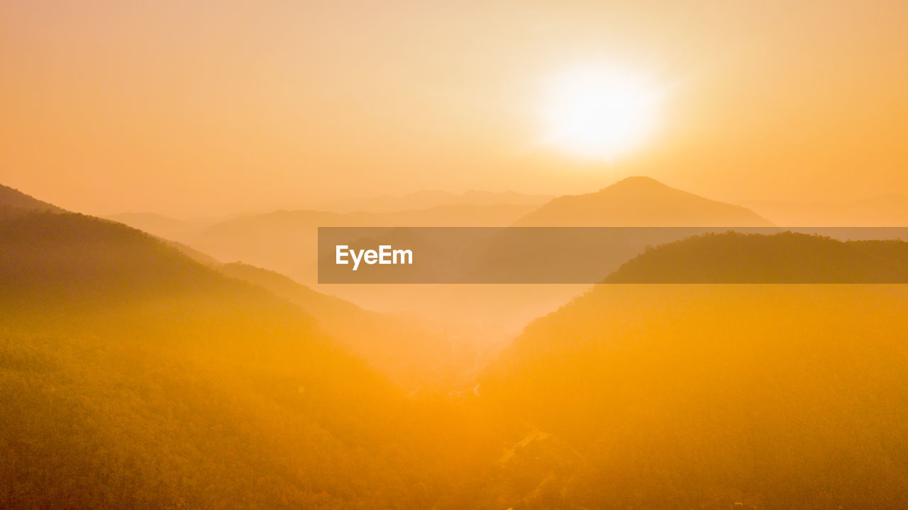 Scenic view of mountains against orange sky