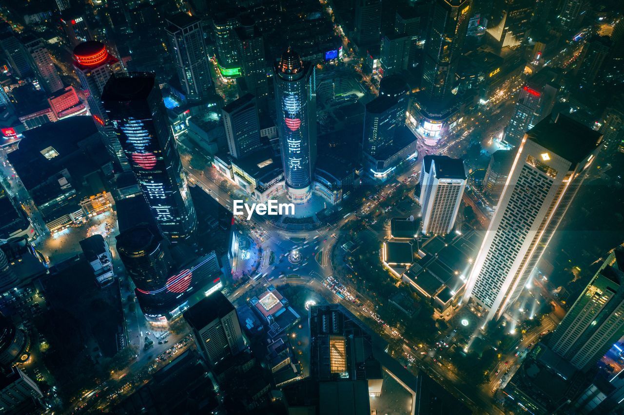 HIGH ANGLE VIEW OF ILLUMINATED MODERN CITY BUILDINGS AT NIGHT