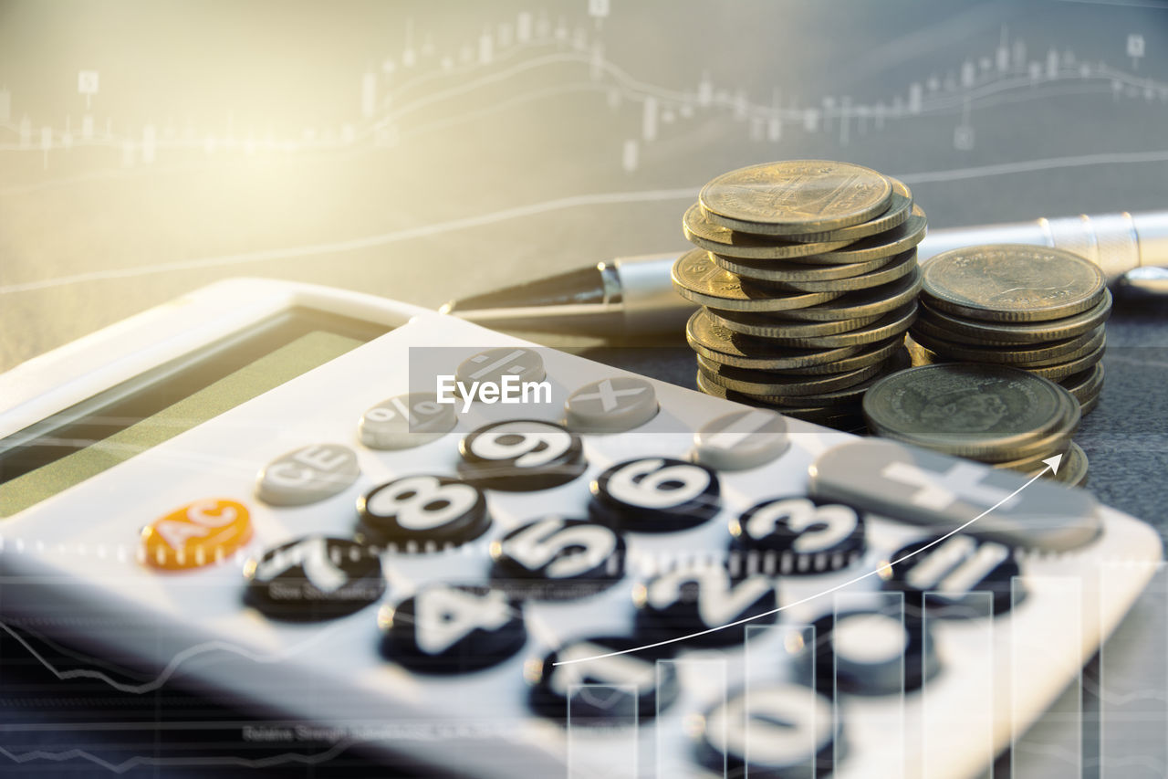 Digital composite image of coins and calculator on table