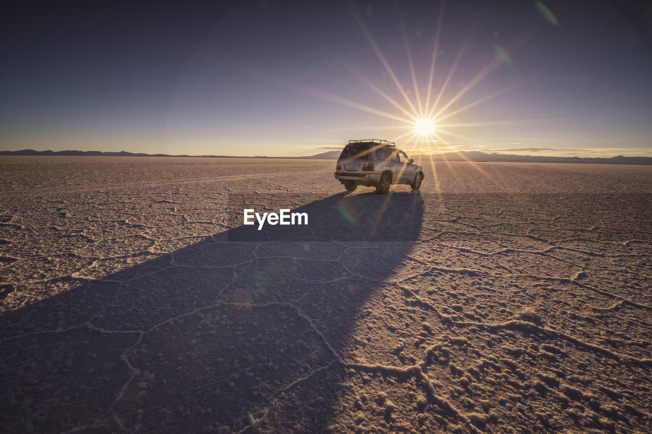 Car over uyuni salar at sunrise