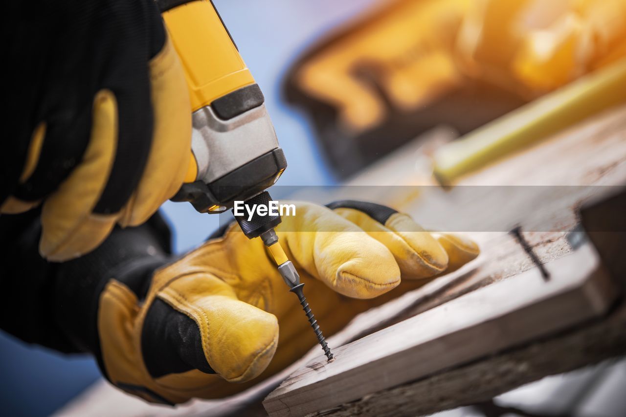 Cropped image of worker drilling wood