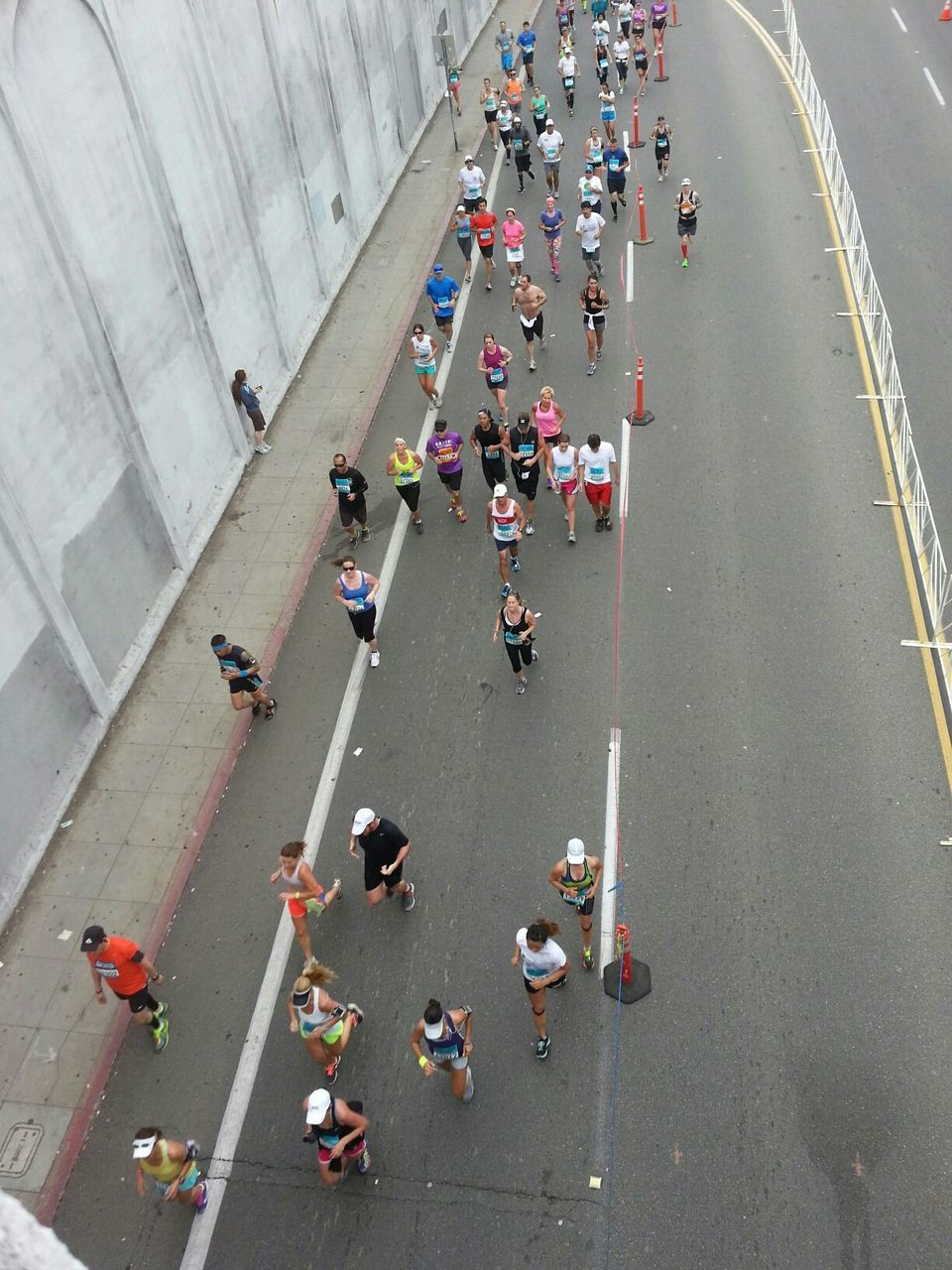 High angle view of people running marathon on city street