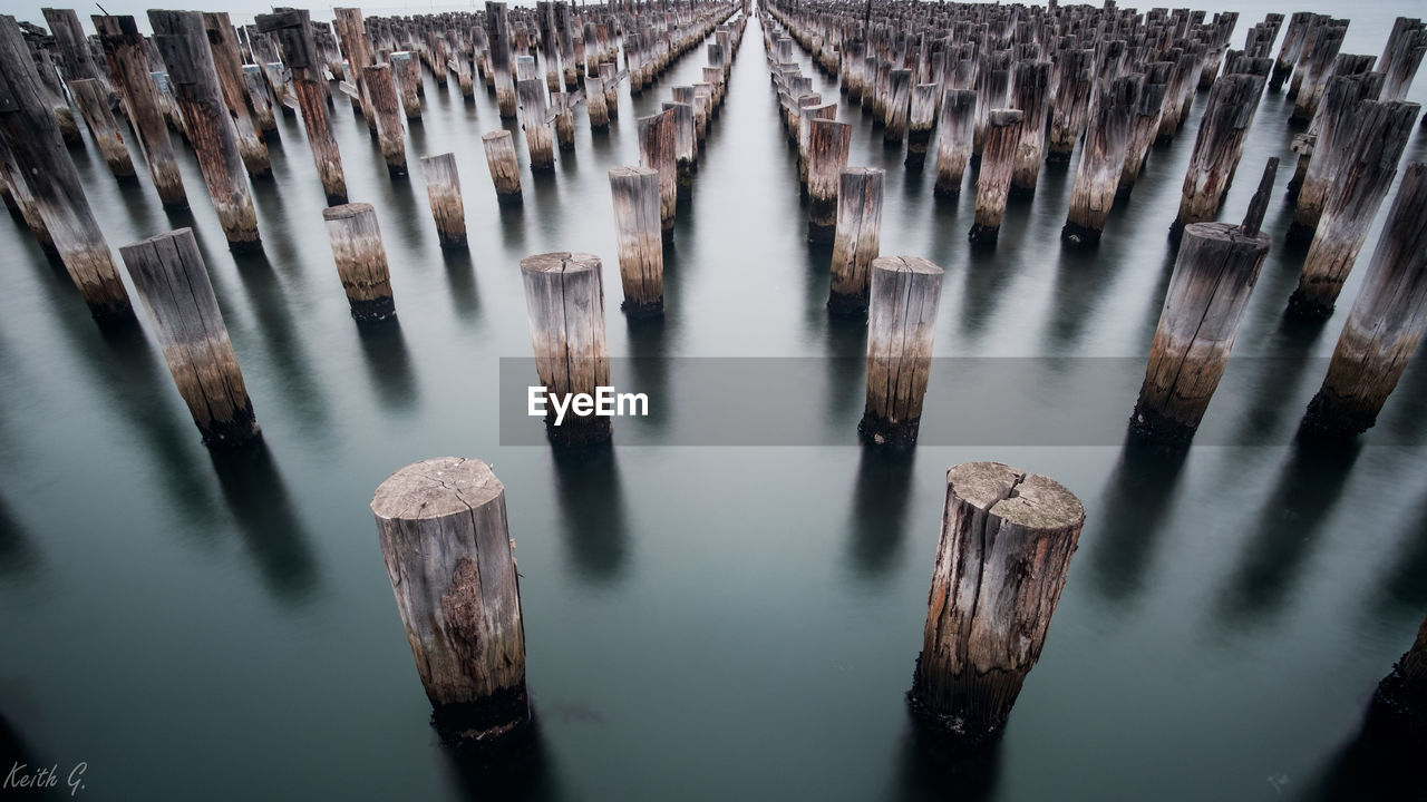 High angle view of wooden posts in river