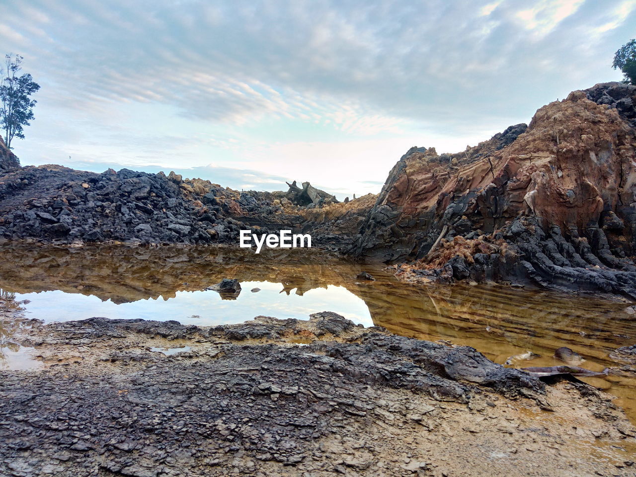 Rock formations in water against sky