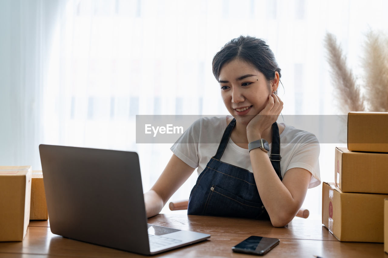 businesswoman using laptop while sitting at office