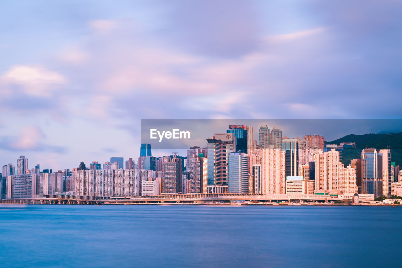 Sea by buildings against sky in city