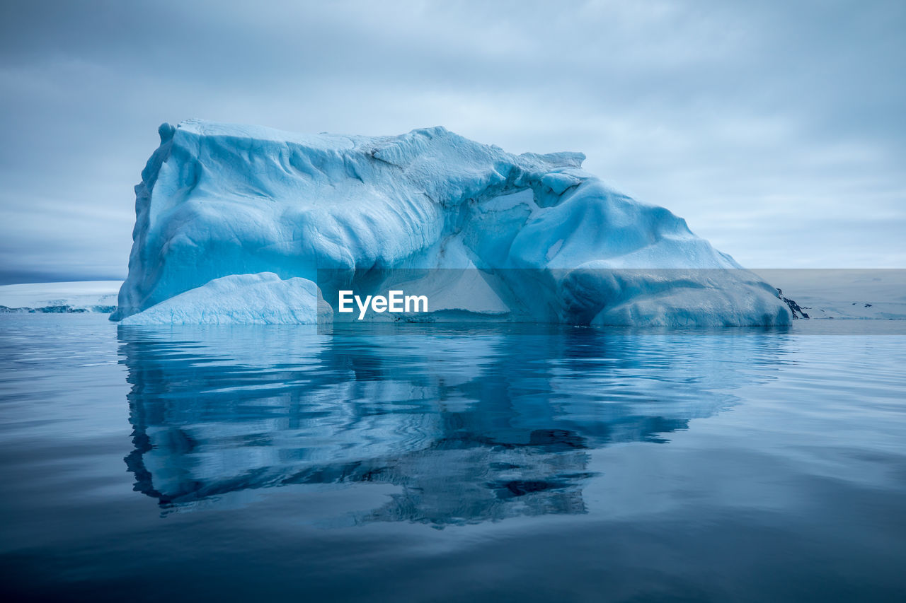 Scenic view of ice berg in lake against sky