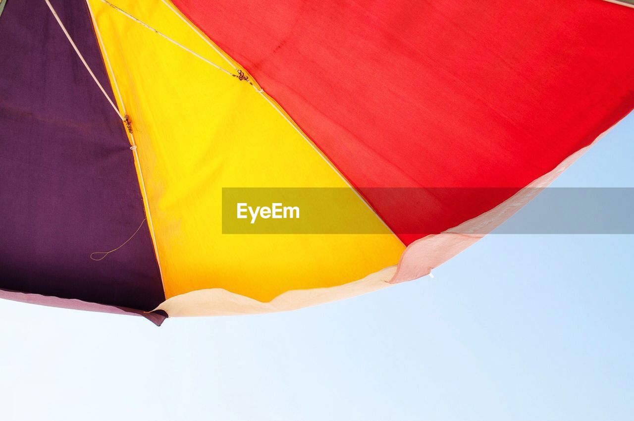 Low angle view of colorful umbrella against clear sky