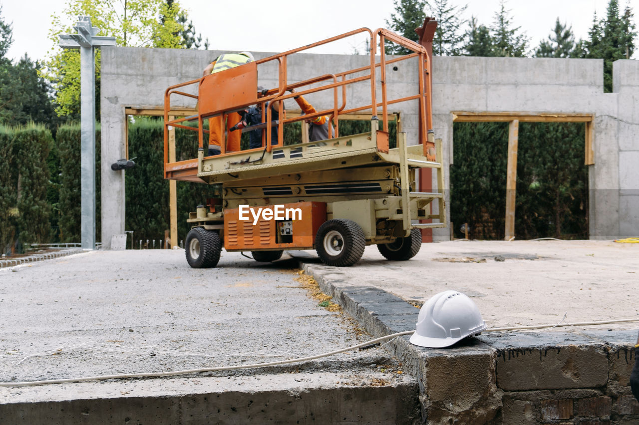 Scissor lift platform on a construction site. building concreate house with mobile transportation