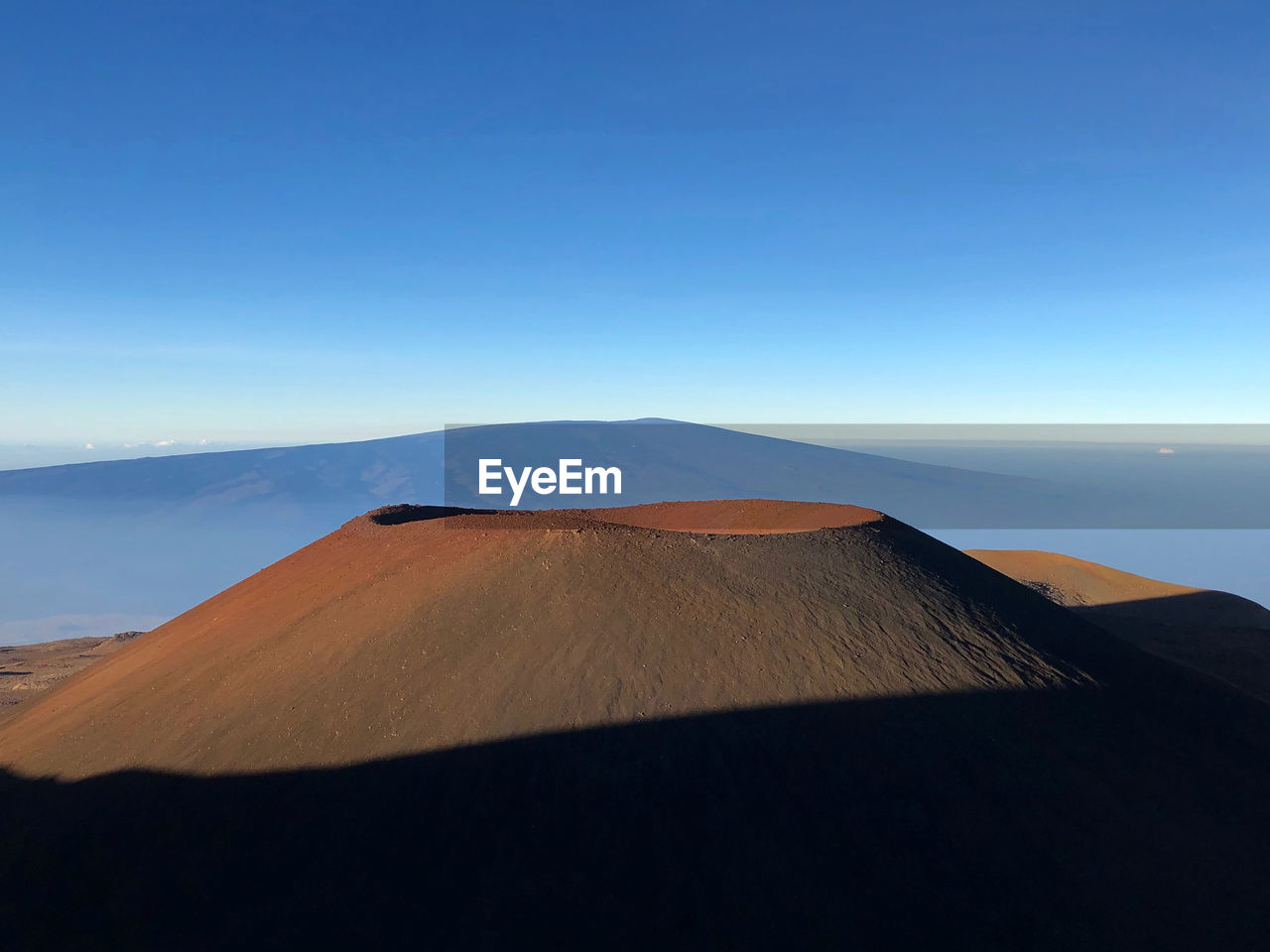 Scenic view of mountain and volcanic crater against blue sky on big island of hawaii