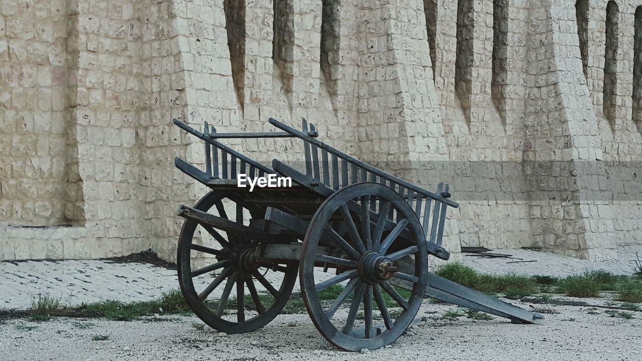 Old cart against stone wall