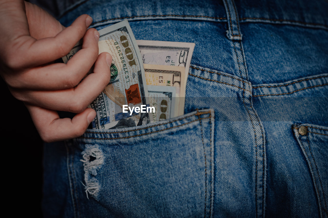 jeans, denim, currency, casual clothing, finance, pocket, clothing, paper currency, blue, textile, one person, hand, business, wealth, close-up, midsection, adult, indoors, holding, trousers, men