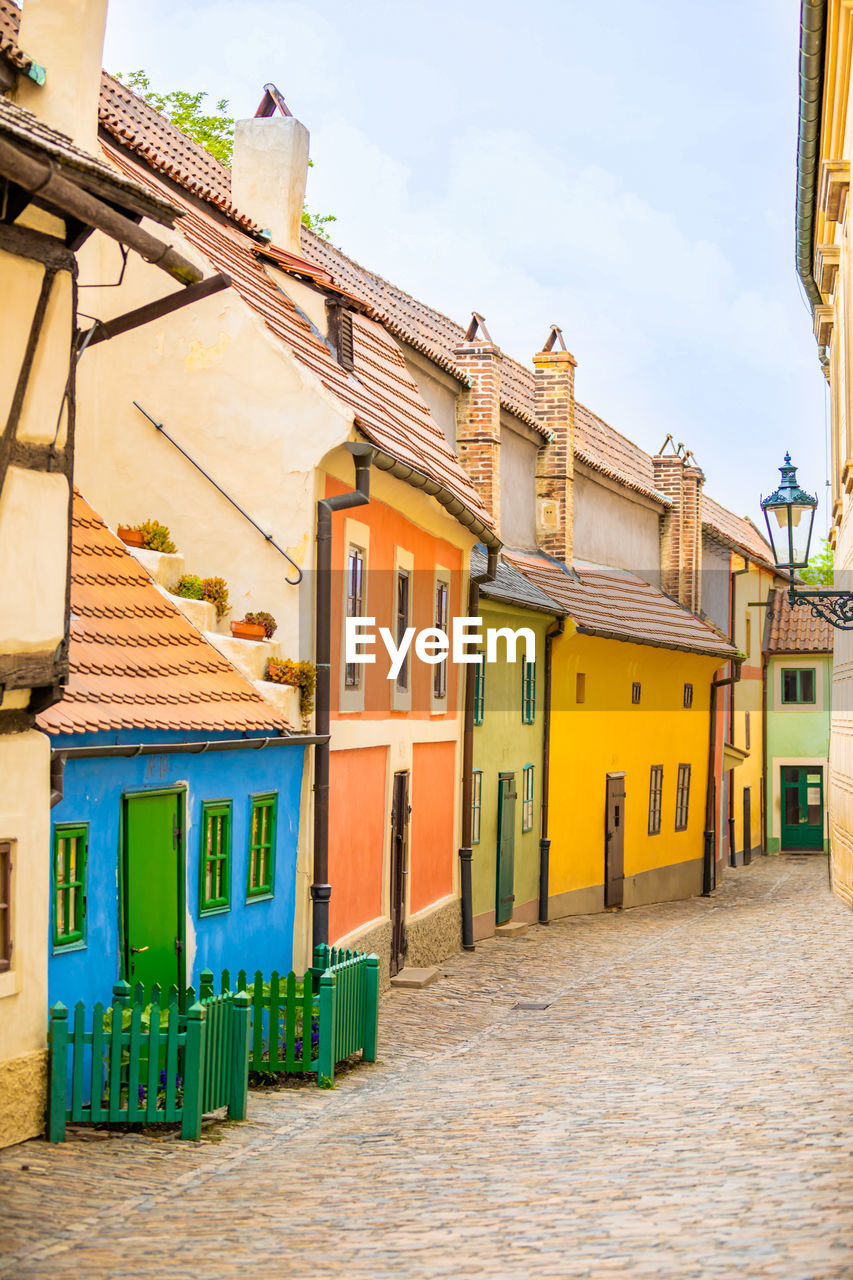 MULTI COLORED HOUSES BY STREET AGAINST SKY