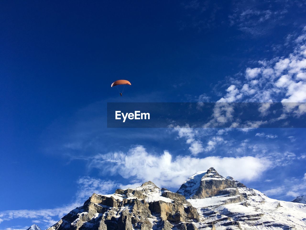 Low angle view of people on mountain against sky