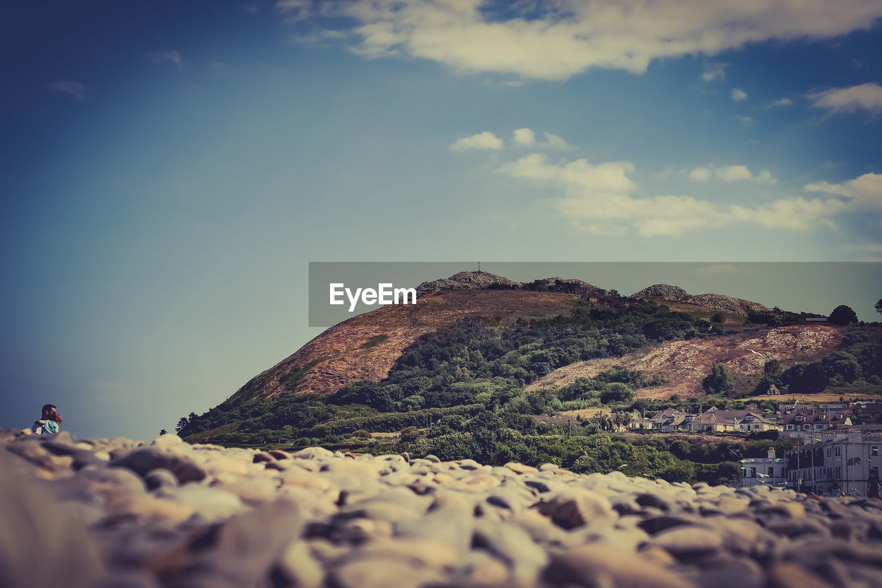 Surface level of rocks on land against sky