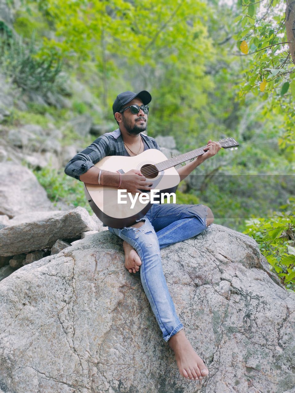 Man playing guitar on rock