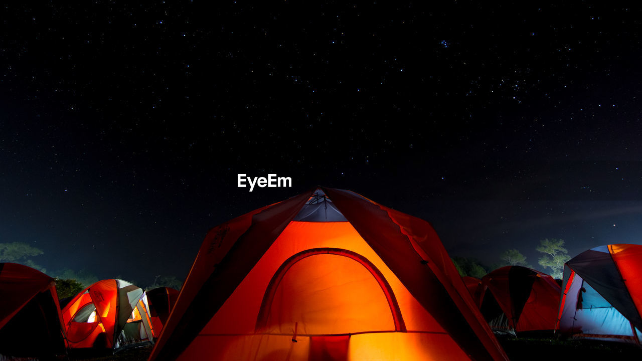 The orange tent under night sky and stars. location place phu kra dueng national park of thailand.