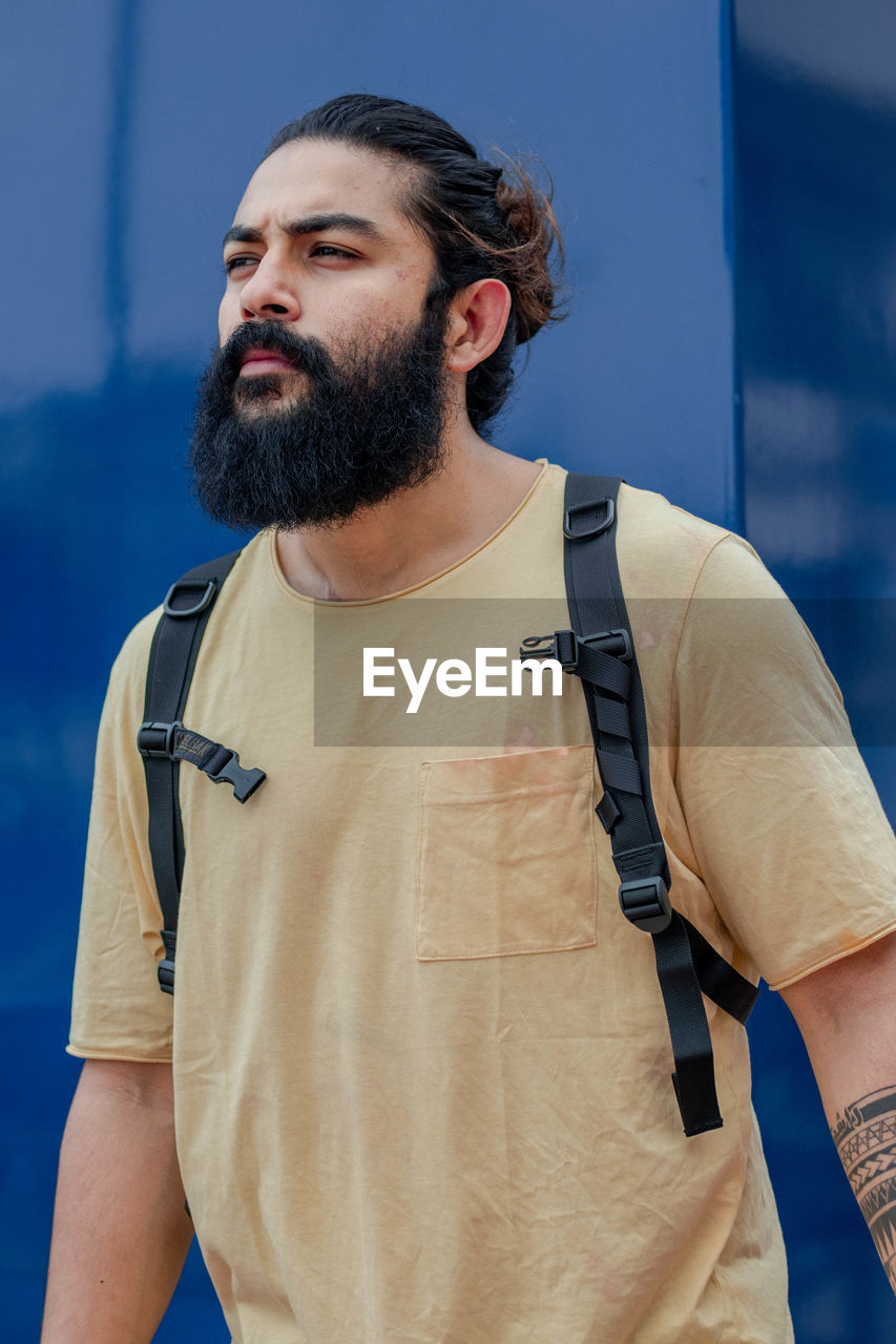 Bearded mature man looking away while standing outdoors