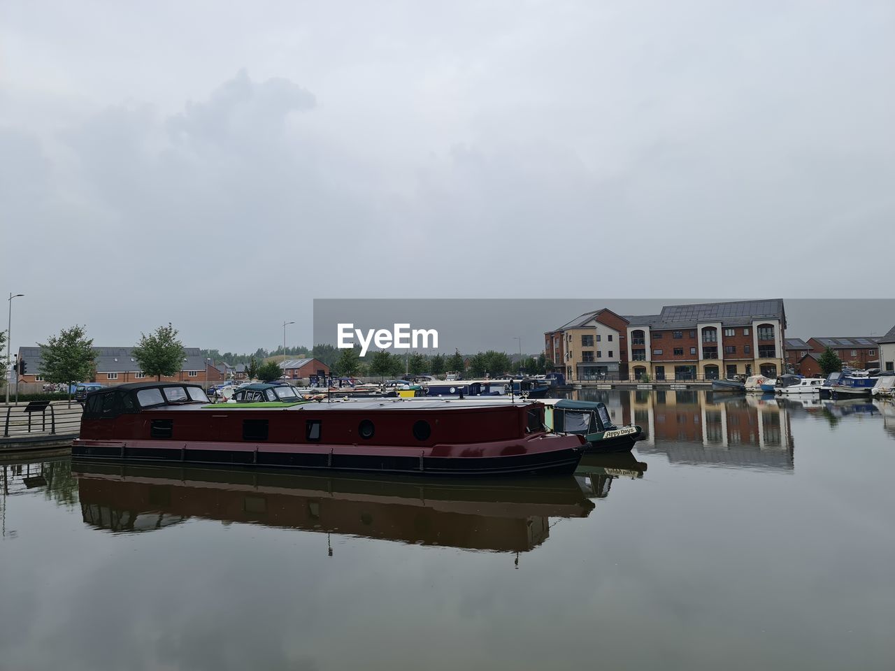 BOATS MOORED IN LAKE AGAINST BUILDINGS