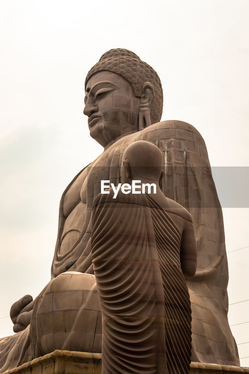 LOW ANGLE VIEW OF A STATUE OF A TEMPLE