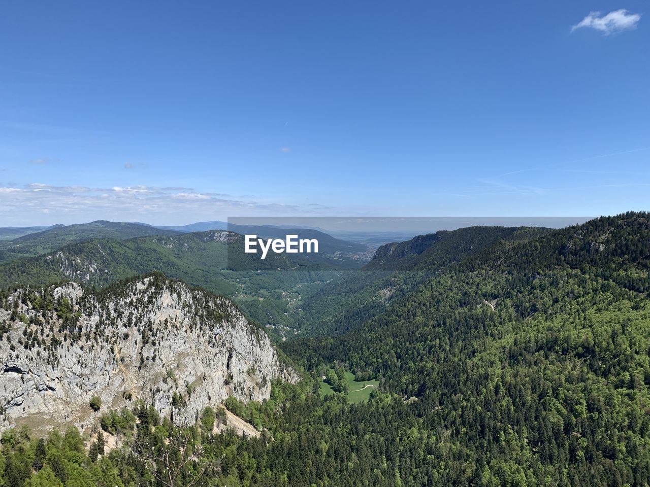 Scenic view of landscape and mountains against blue sky