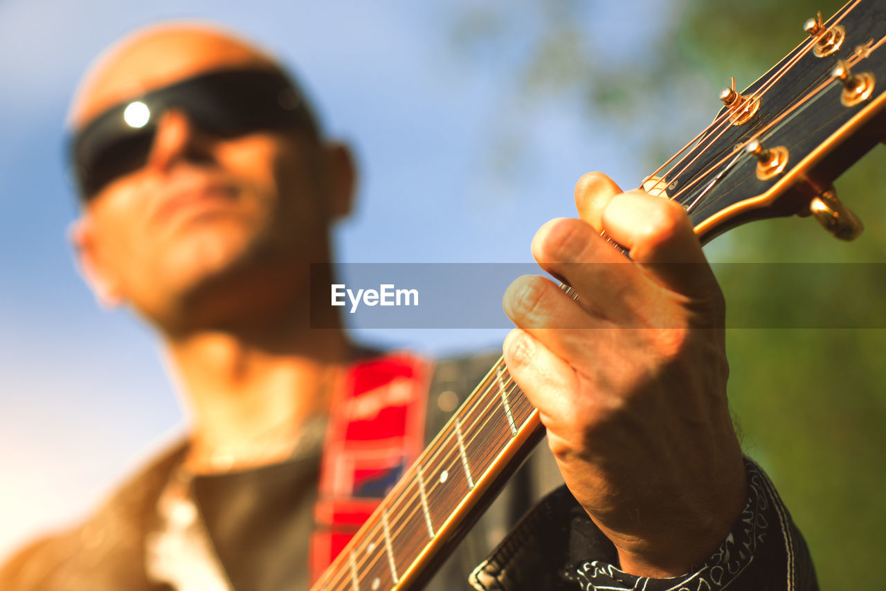 Close-up of man playing guitar