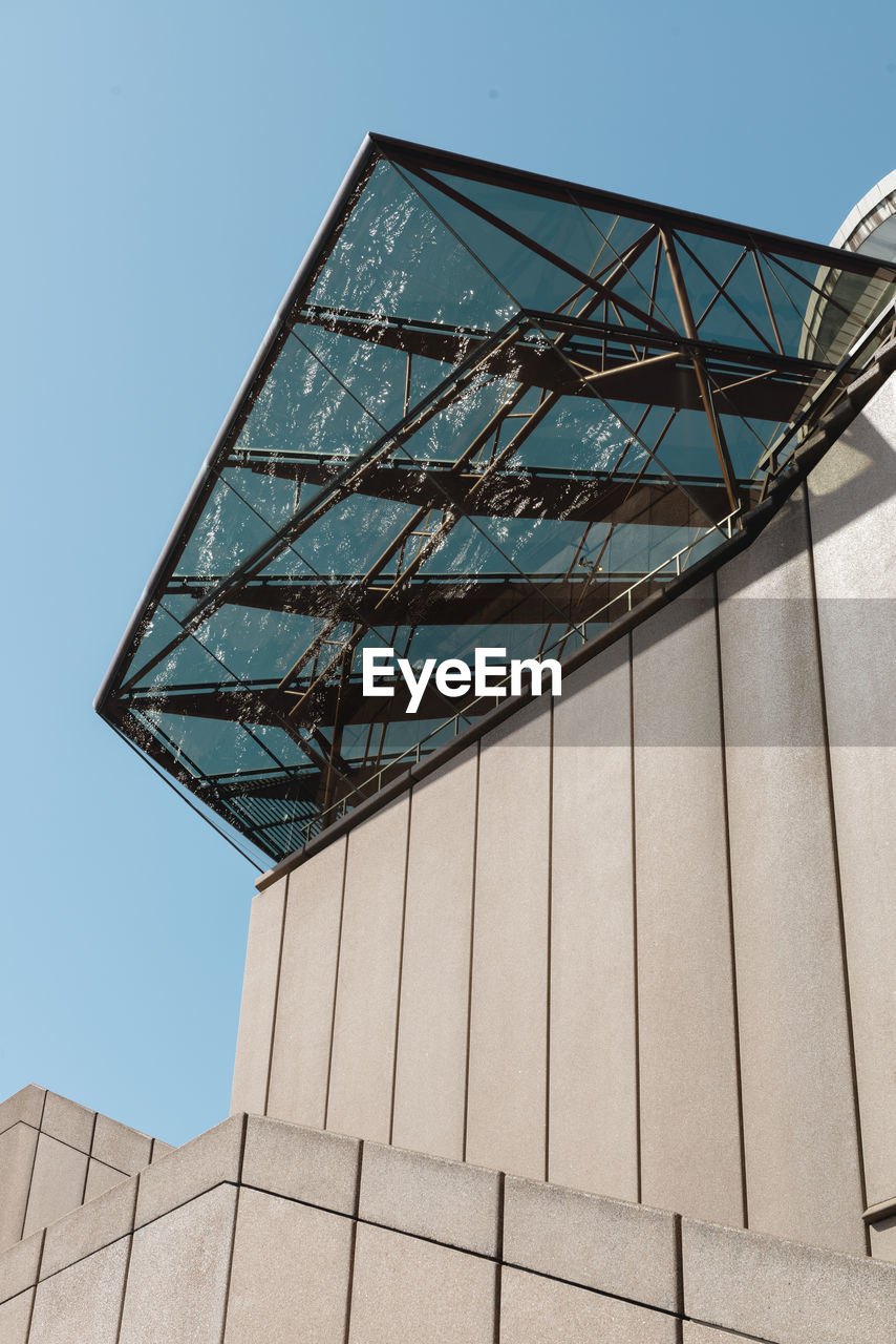 LOW ANGLE VIEW OF MODERN BUILDING AGAINST CLEAR BLUE SKY