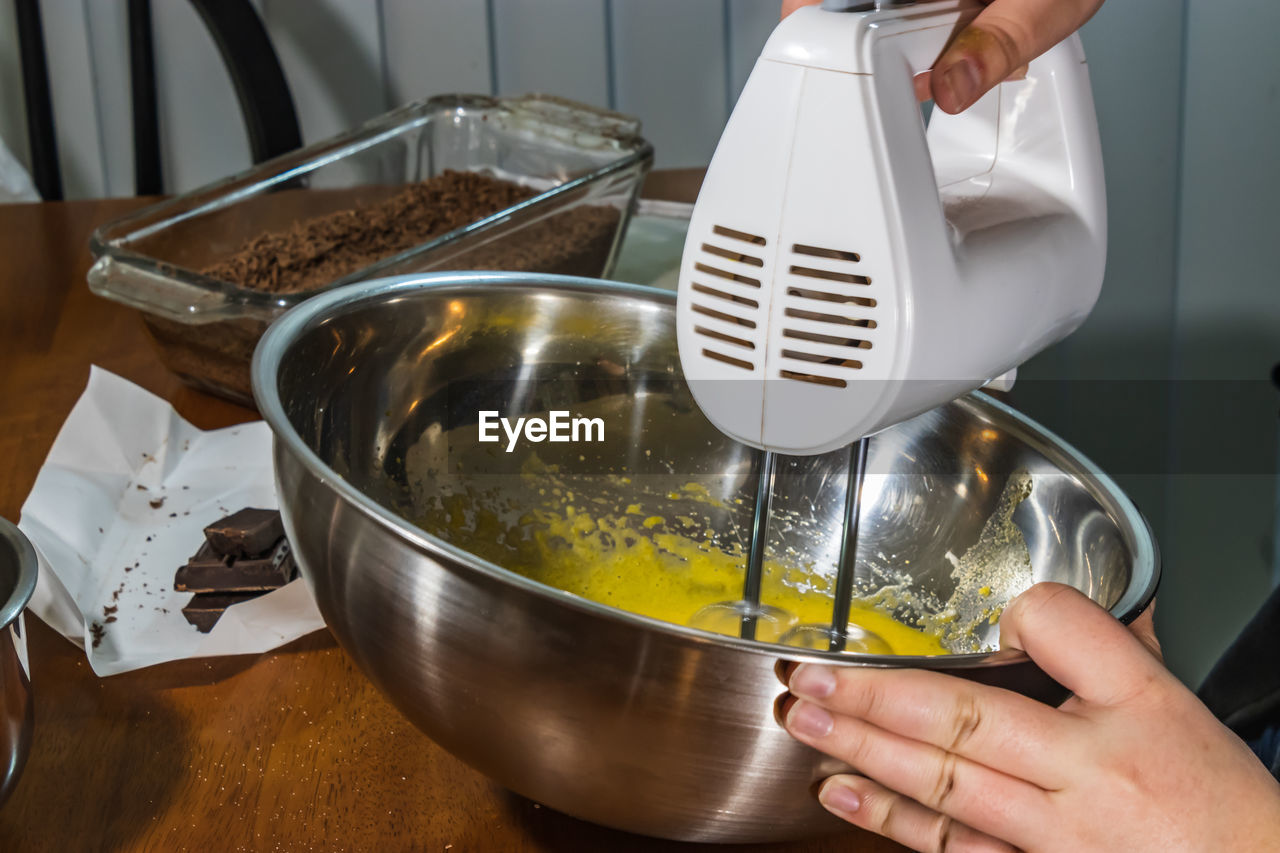 MIDSECTION OF PERSON POURING COFFEE IN KITCHEN