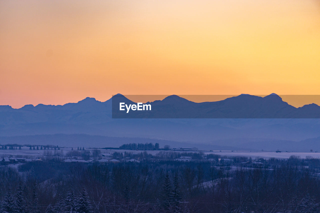 Scenic view of silhouette mountains against clear sky at sunset