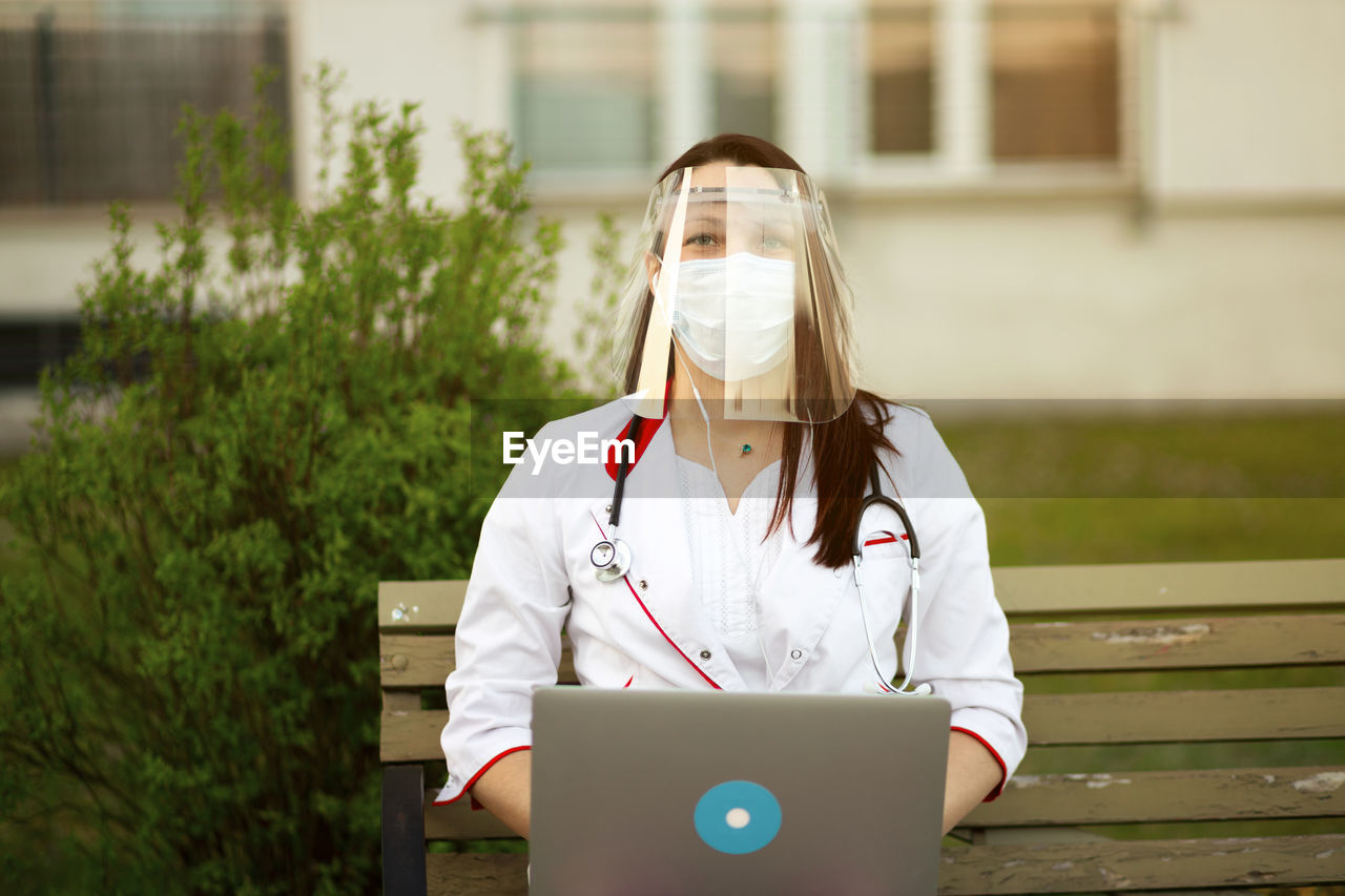 woman using mobile phone while sitting on table