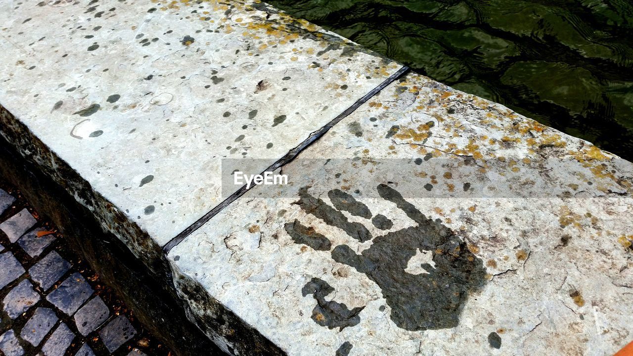 High angle view of handprint on retaining wall