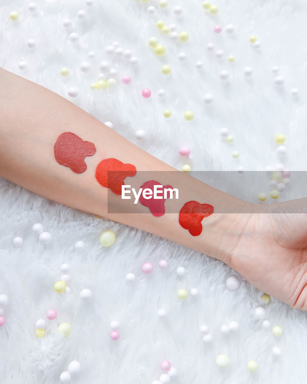 Cropped hand of woman with make-up on table