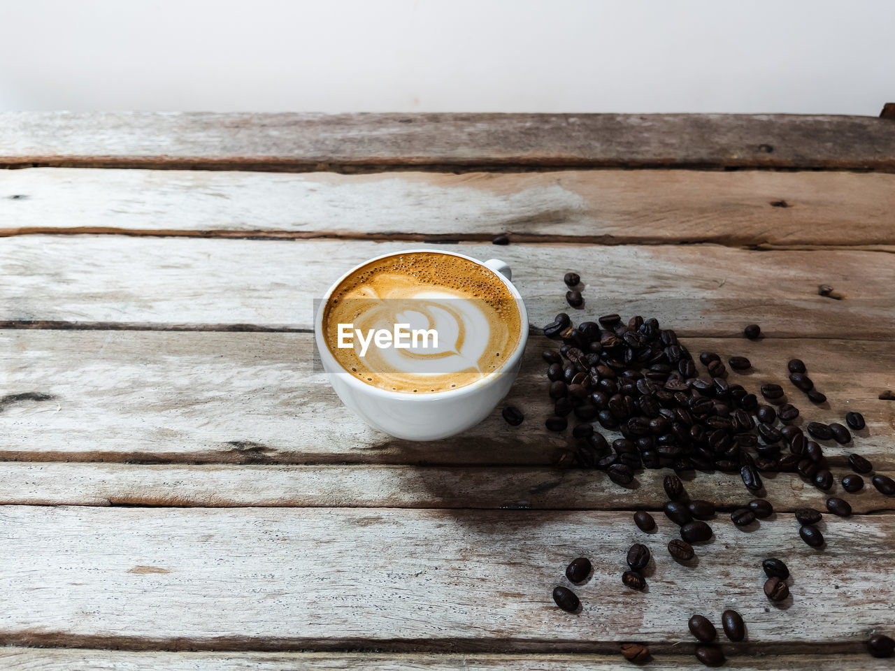 COFFEE CUP ON TABLE AGAINST WALL