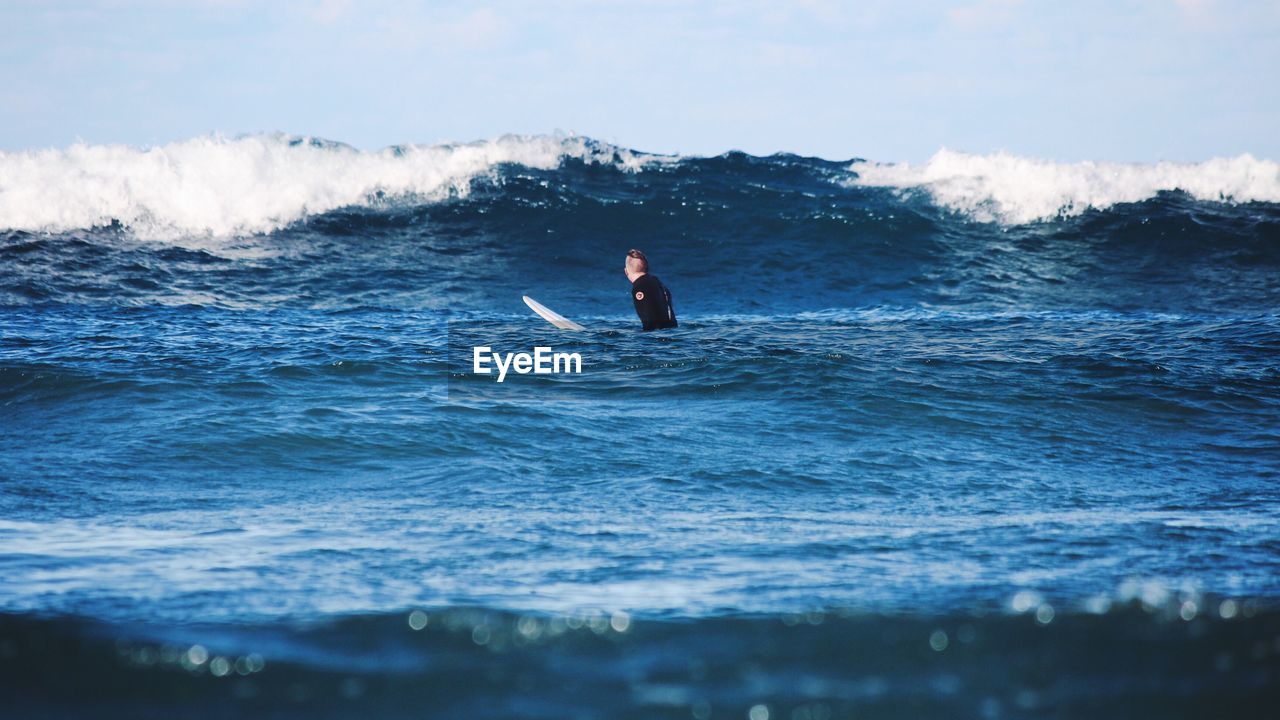 MAN SURFING ON SEA