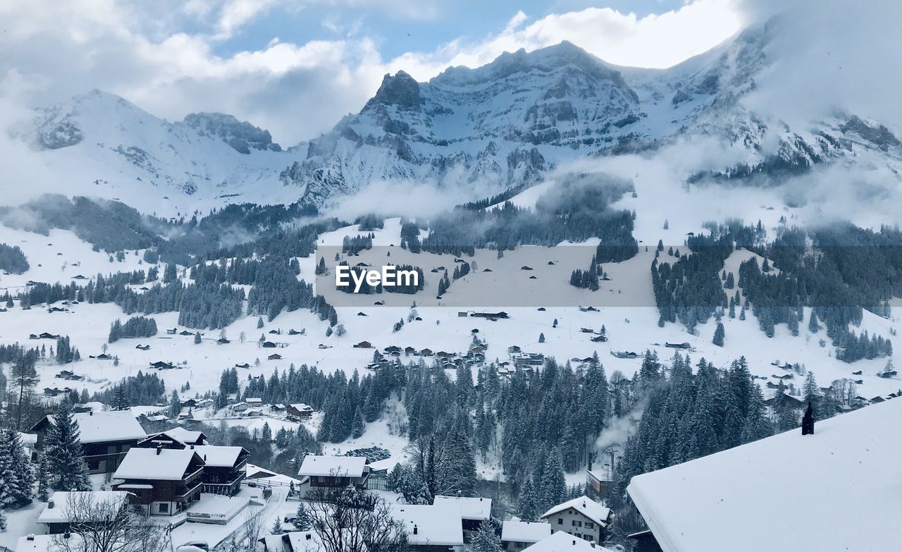 Aerial view of townscape by snow covered mountains