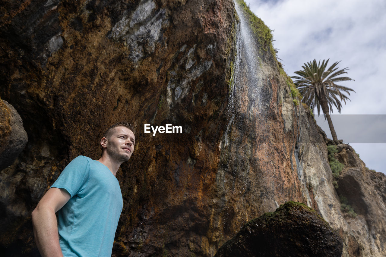 Man standing under waterfall in tenerife, canary island, spain.