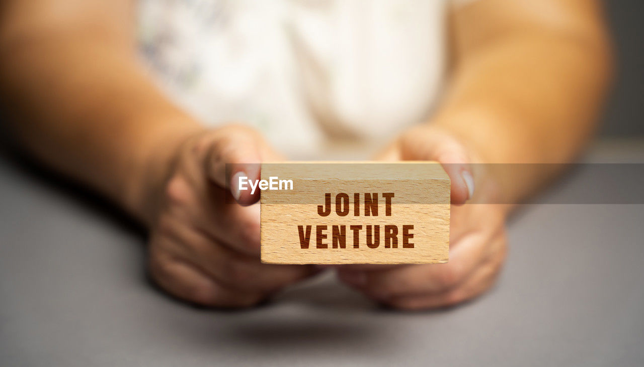 Joint venture on blocks concept. jv is a business entity created by two who parties shared returns 