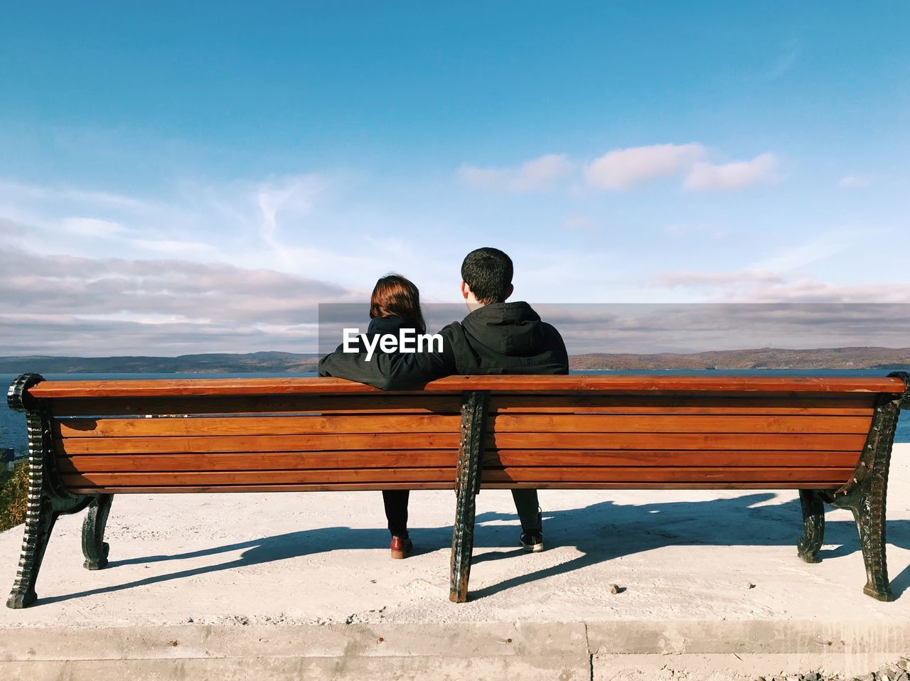 COUPLE SITTING ON BENCH IN PARK