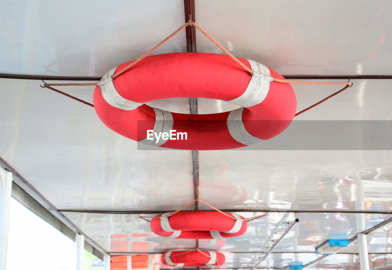 Safety and life rescuing concept - lifebuoy hanging on fence over moored boats on pier