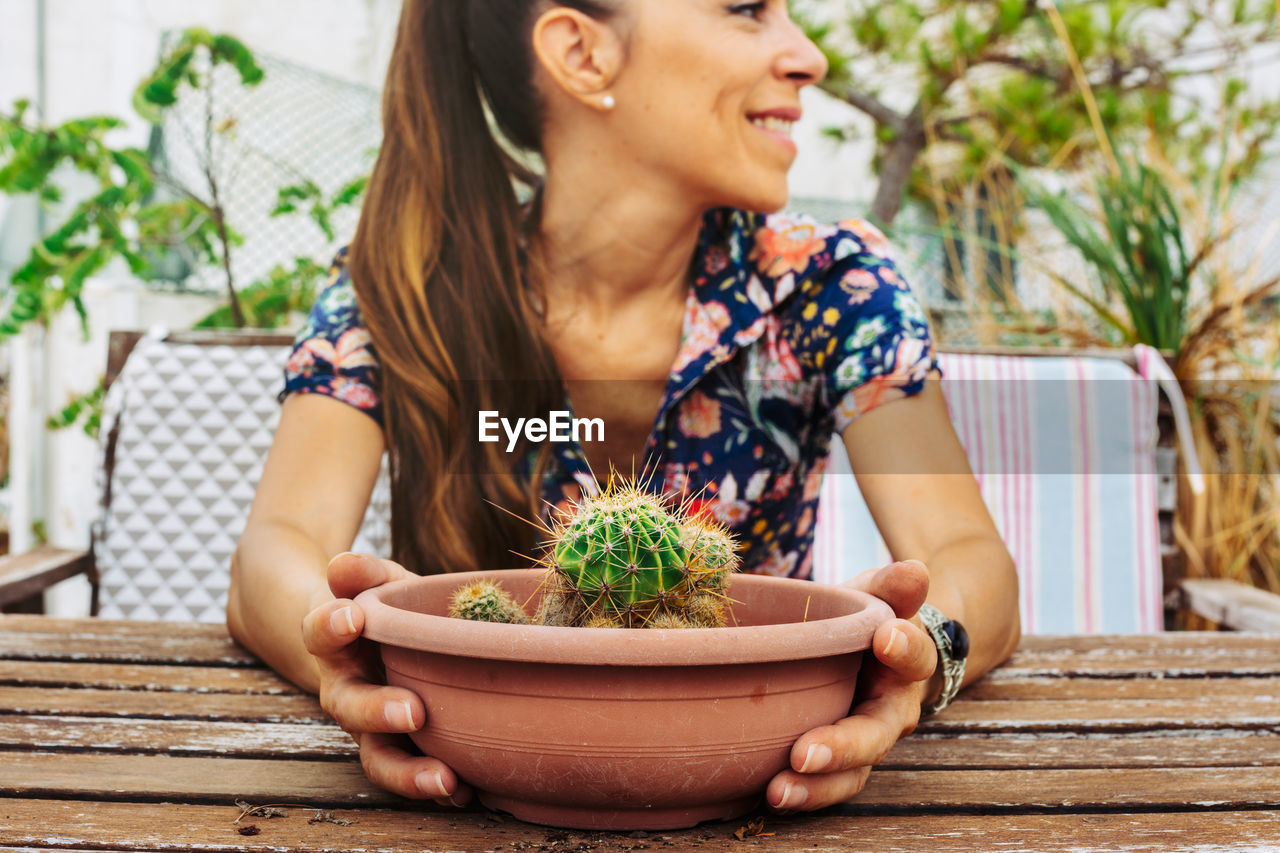 Midsection of woman with potted plant