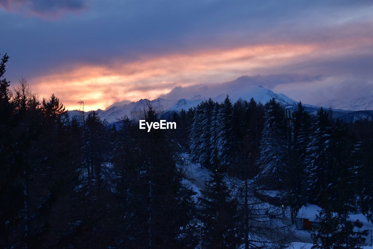 Scenic view of snowcapped mountains against sky at sunset