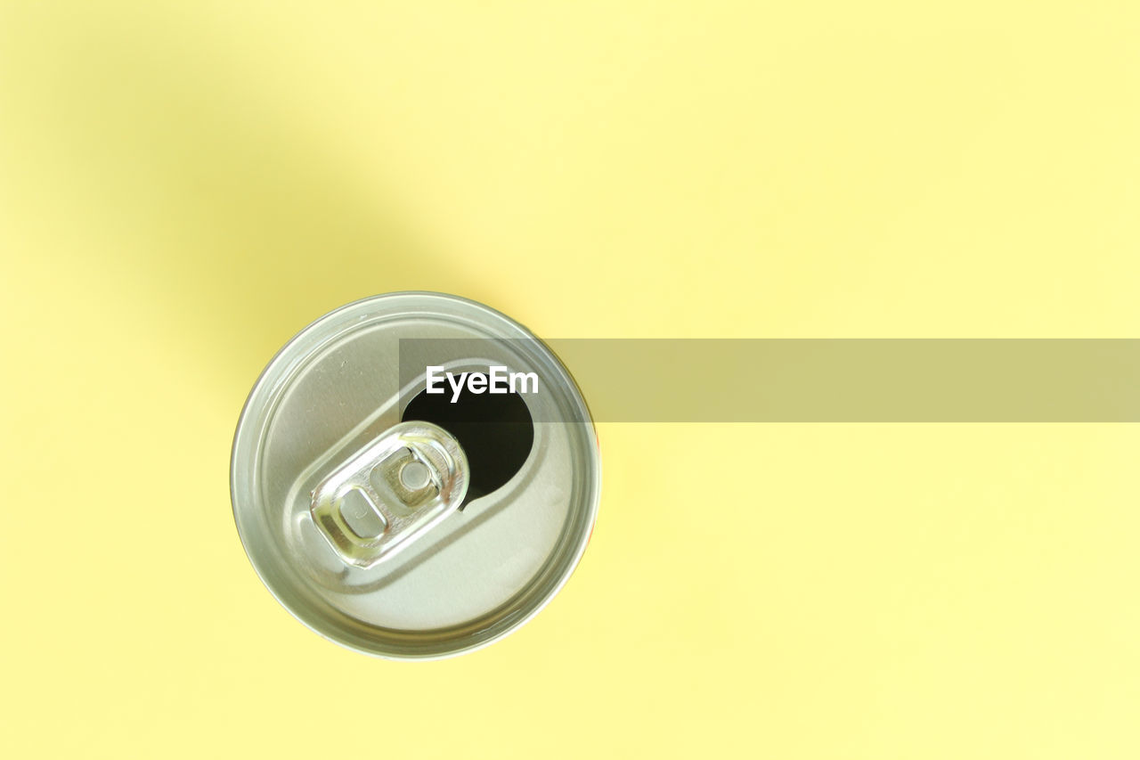 Directly above shot of drink can on yellow background