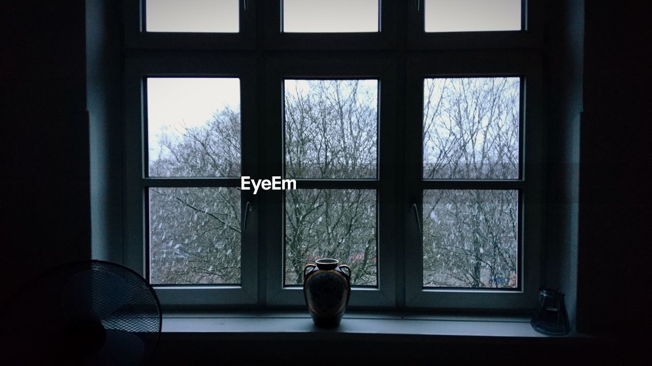 SILHOUETTE WOMAN STANDING BY WINDOW IN GLASS