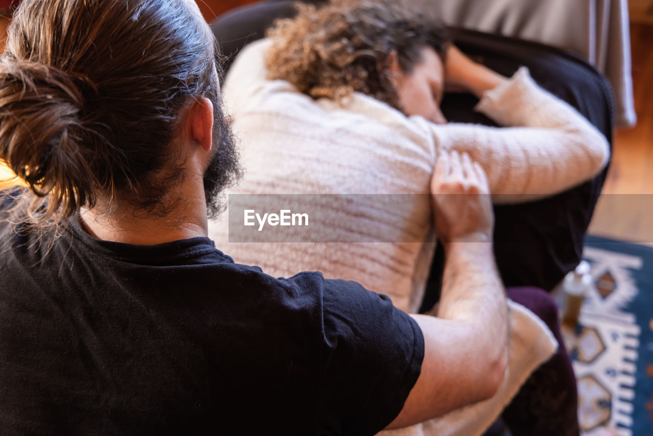 rear view of man using mobile phone at home