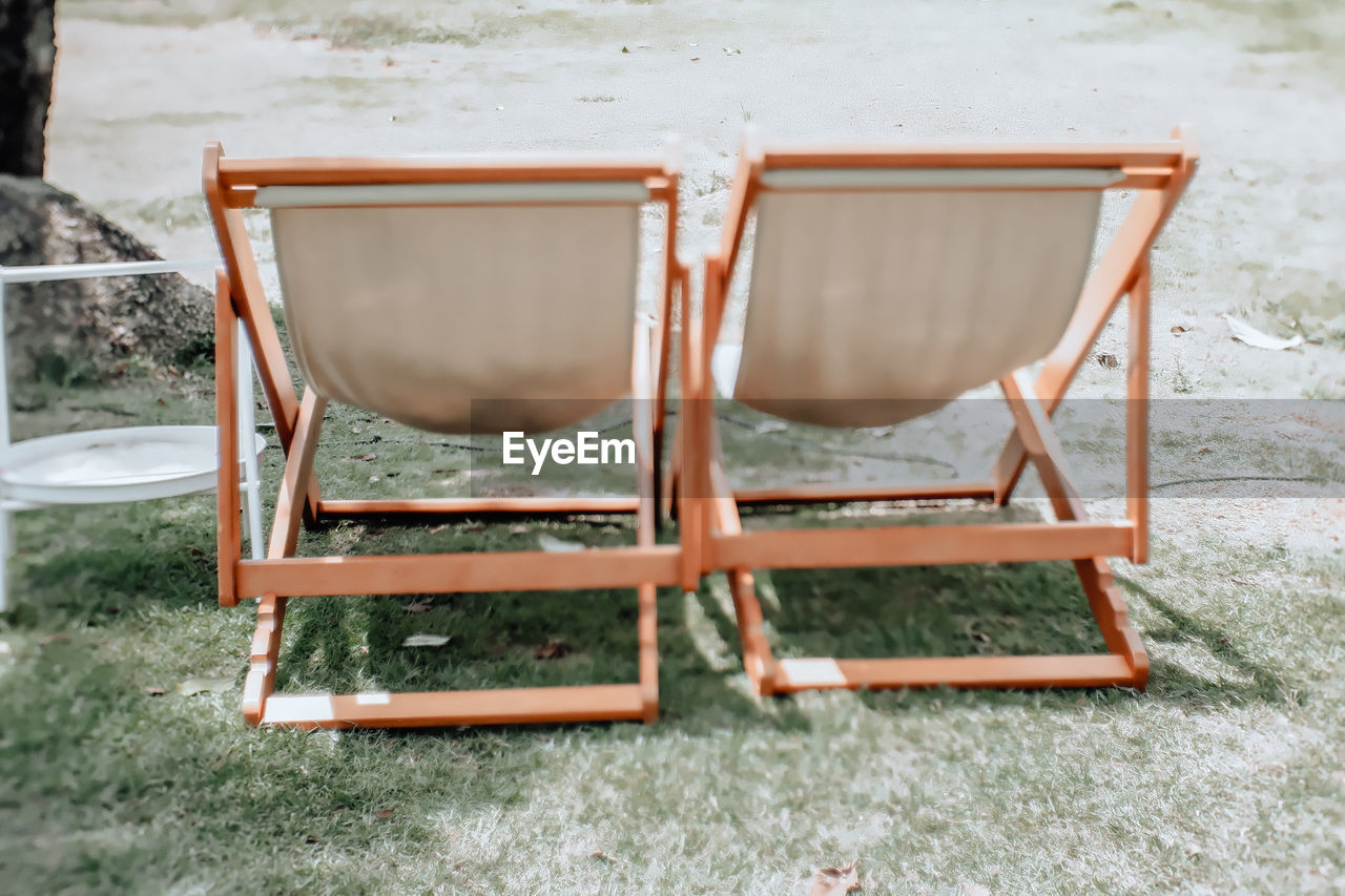 Empty chairs and table on field
