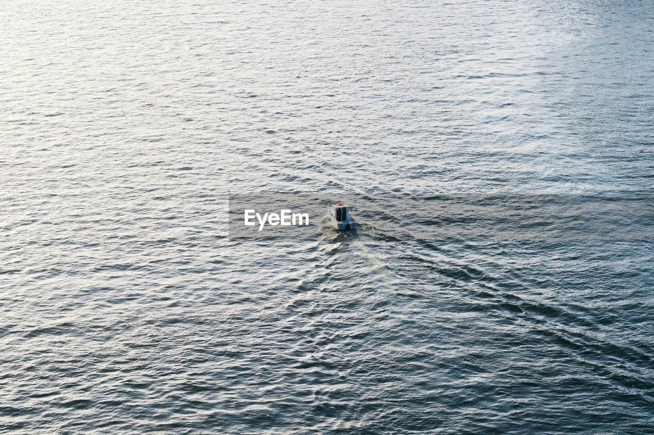 HIGH ANGLE VIEW OF MAN IN BOAT IN SEA