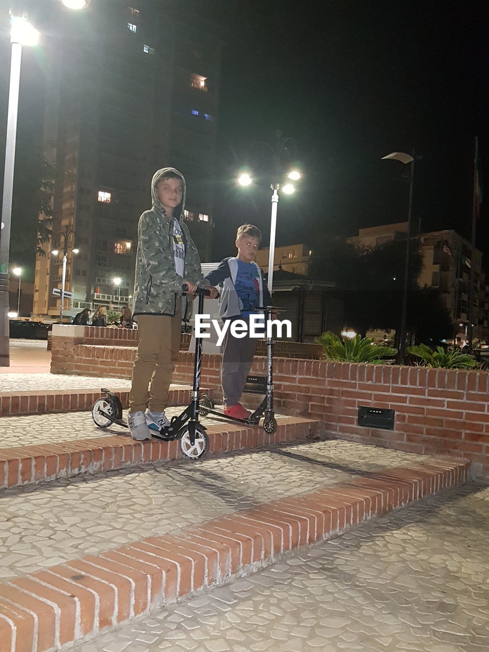 REAR VIEW OF PEOPLE ON STREET AT NIGHT DURING FESTIVAL