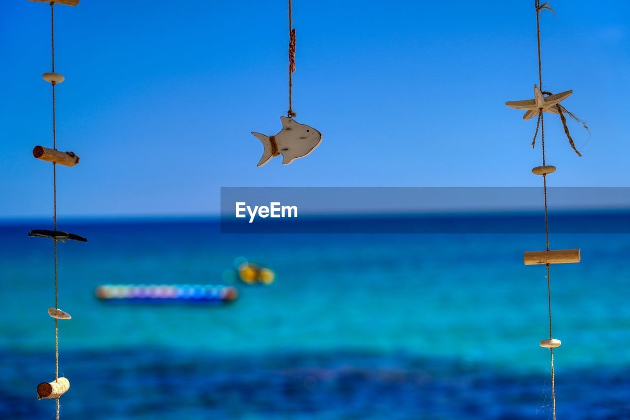 View of birds in sea against clear blue sky