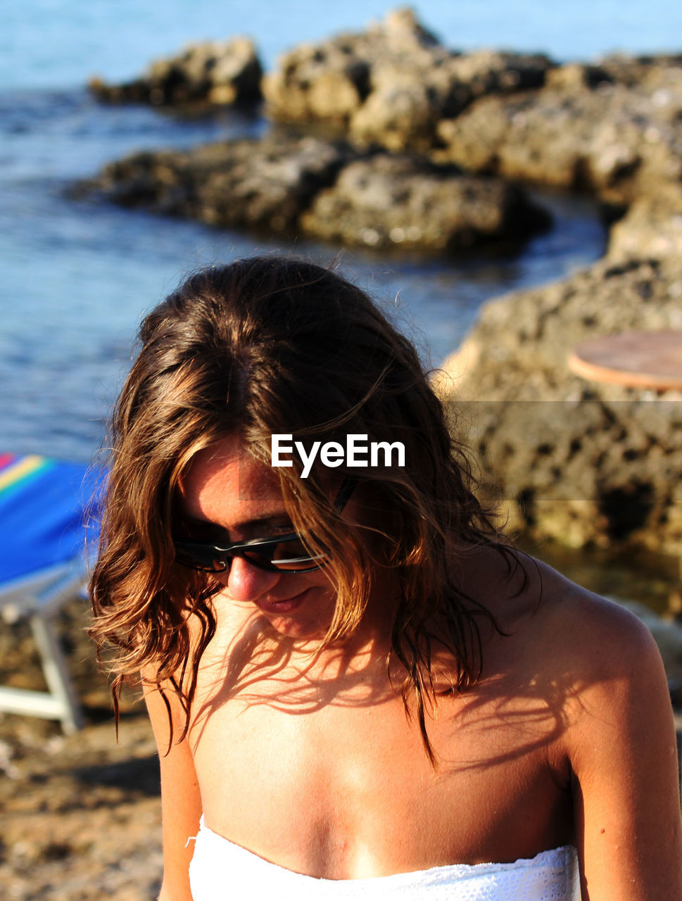 Close-up of woman wearing sunglasses at beach